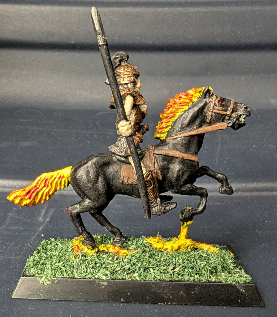 Skeleton riding a flaming black horse with a spear viewed from the right.
